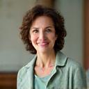 Portretul relaxat al Psih. Corina Neagu, psiholog, purtând o ținută profesională, transmițând empatie și calm.